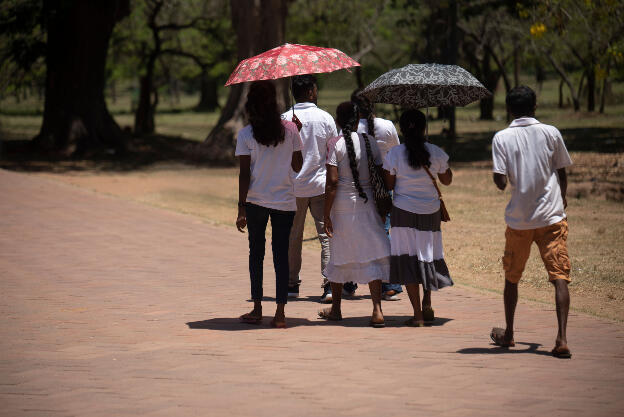 Family walking in the heat near Ruwanweli Maha Seya, Anuradhapura, Sri Lanka