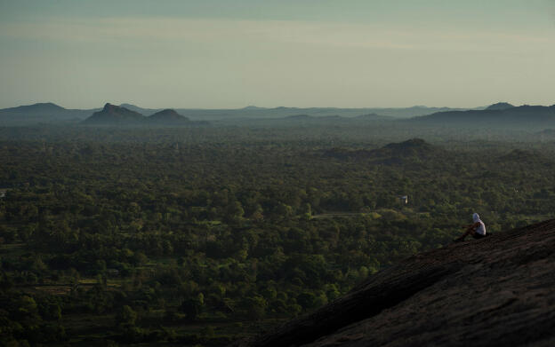 Tourist on top of Pidurangala Rock at Sigiriya, Sri Lanka