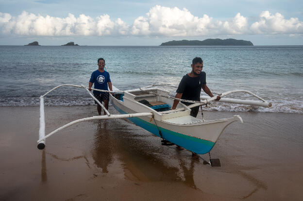 Nacpan Beach, Palawan: Carrying the boat that is heavy with a small diesel engine