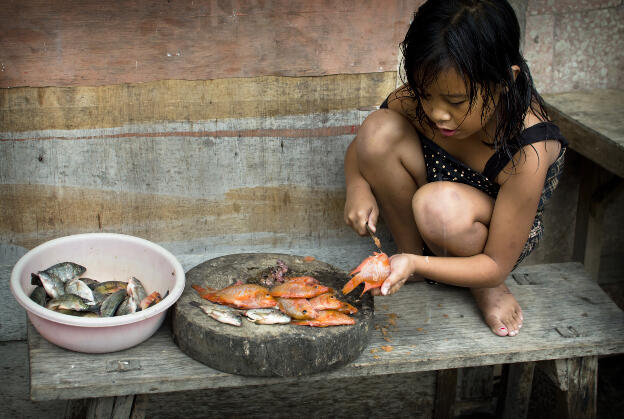 Girl cutting fish in Trunyan