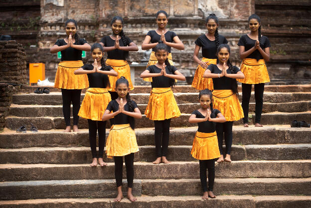 Polonnaruwa, Sri Lanka: Traditional dance group posing in front of Rankoth Vehera stupa ruin